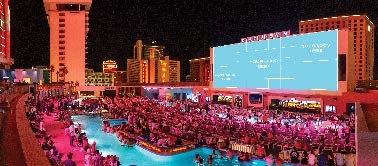 Stadium Swim's massive main screen above the pools at night
